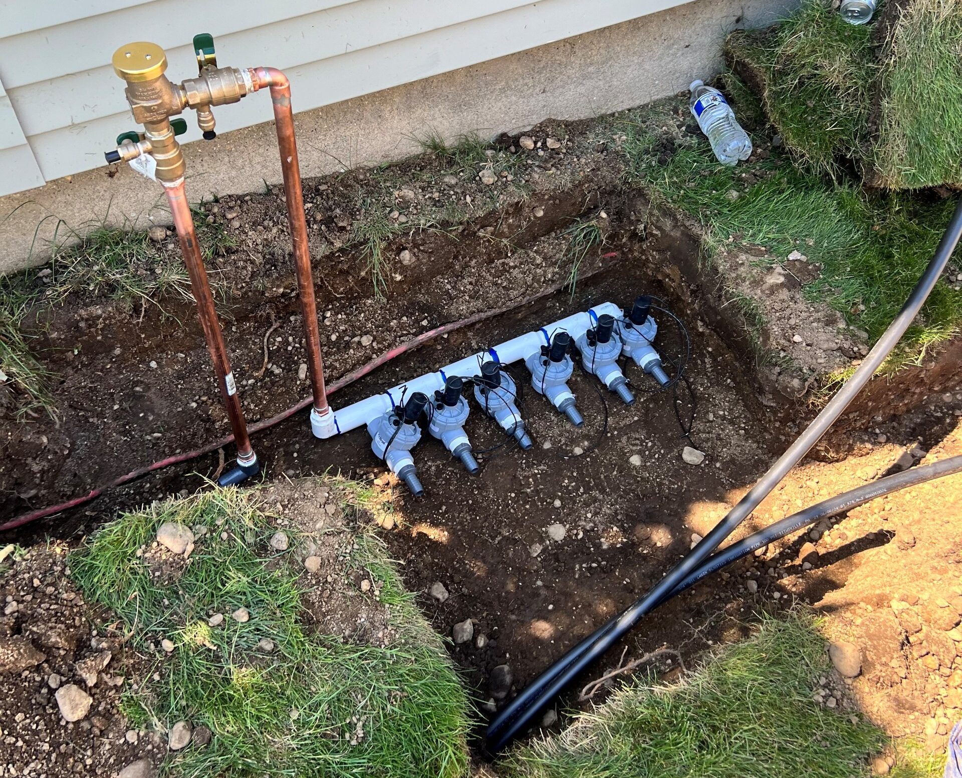 A freshly installed sprinkler manifold and valve system in the ground